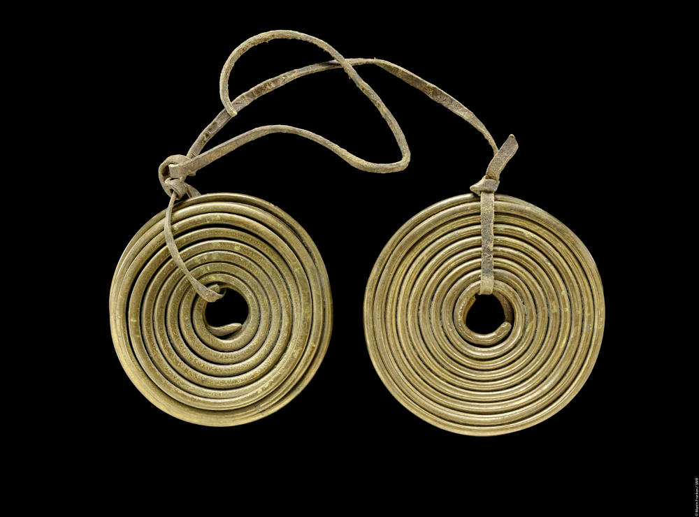 Article Image: Young and old women’s ear pendant, appropriated by Kurt Johannes. Brass and leather. Acquired 1896, Ethnologisches Museum, Staatliche Museen zu Berlin. Photo: Martin Franken.
